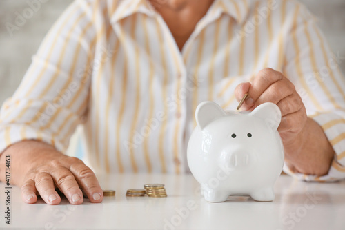 Senior woman putting coin i...