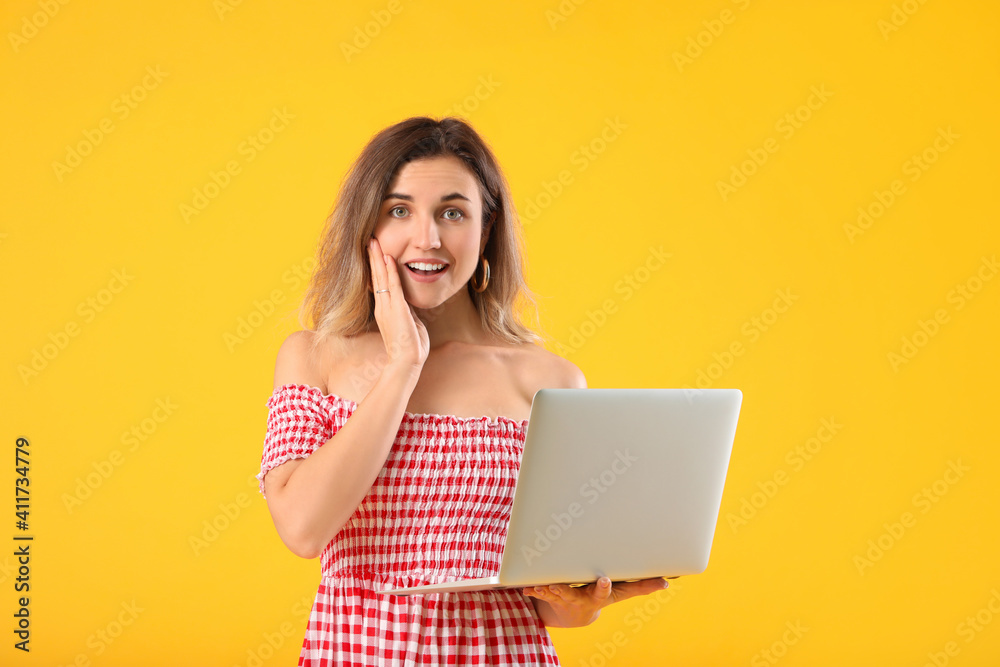 Naklejka premium Happy young woman with laptop on color background