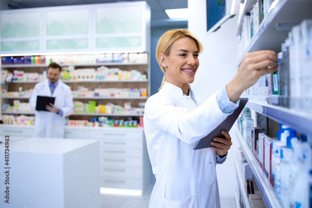 Female pharmacist working in chemist shop or pharmacy.