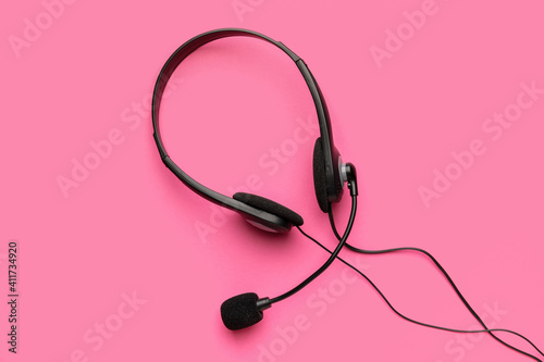 Headphones with microphone on color background