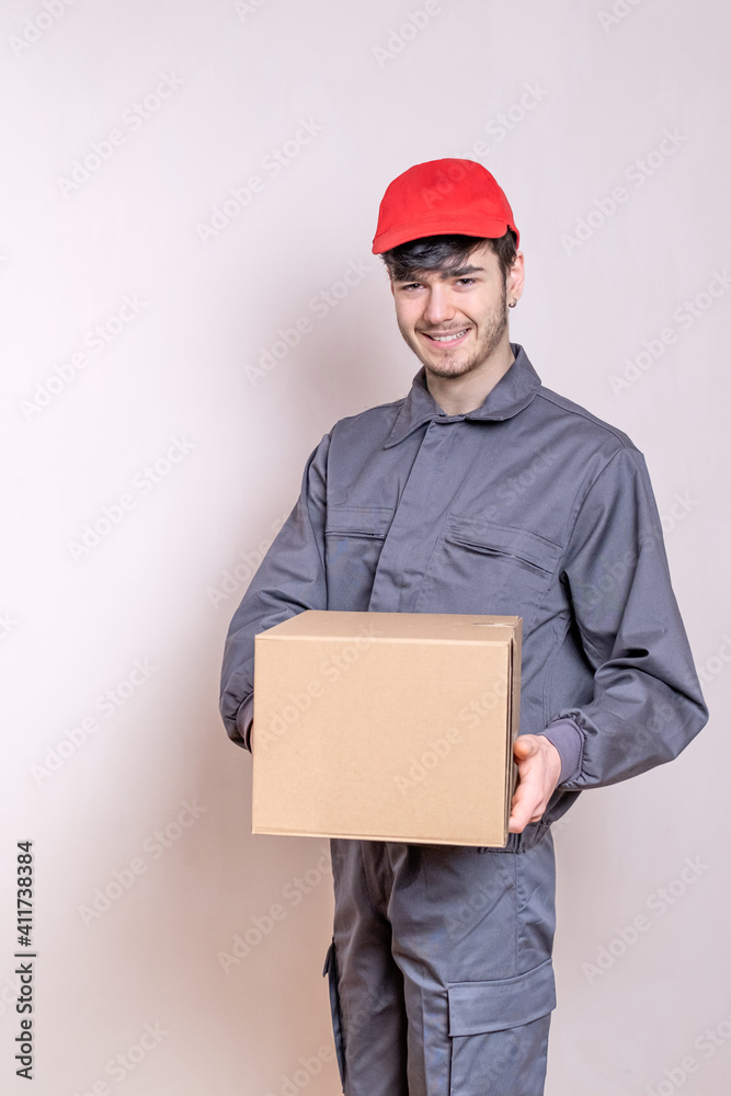 Delivery man in uniform delivering home delivery order, package in cardboard box. Delivery man in uniform delivering home delivery order, package in cardboard box.