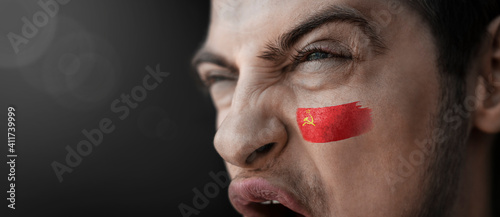 Valokuva A screaming man with the image of the USSR national flag on his face