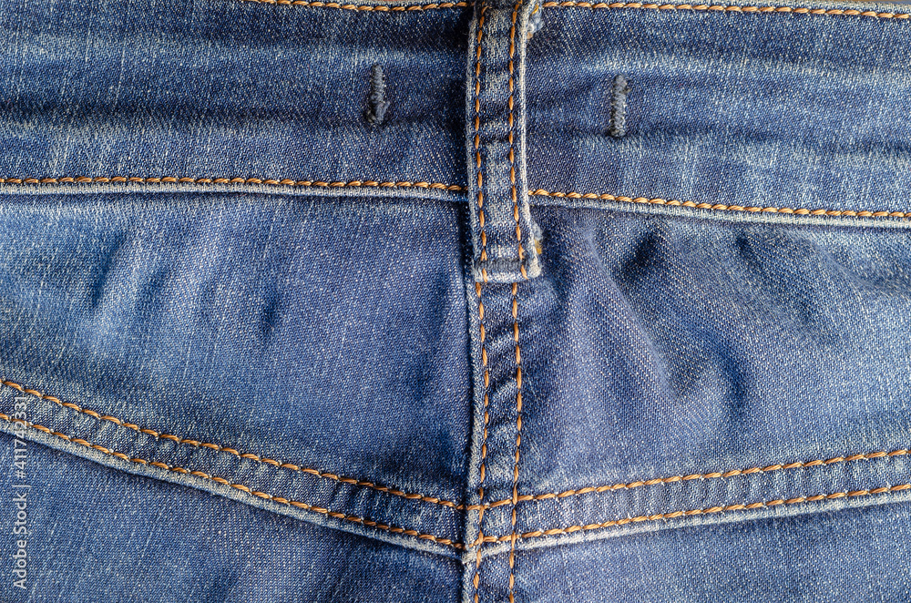 The back of the blue jeans with yellow threads. The back of the blue jeans with yellow threads.