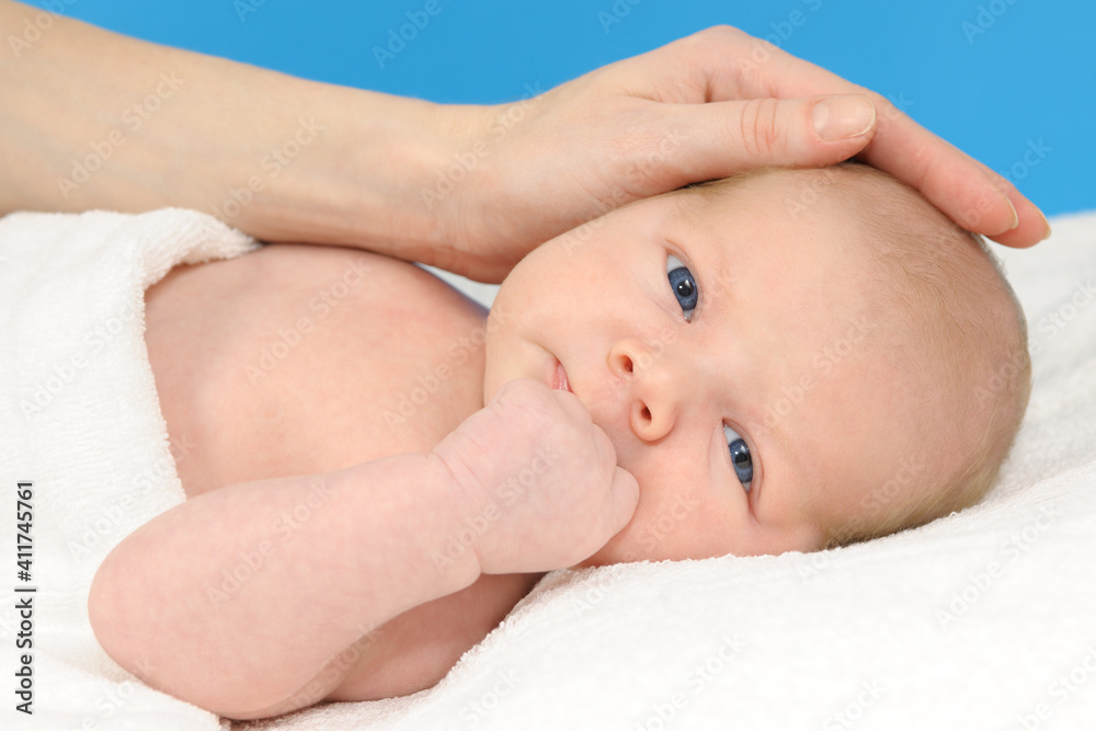 Baby girl lying on a white blanket and his mother's hand Baby girl lying on a white blanket and his mother's hand