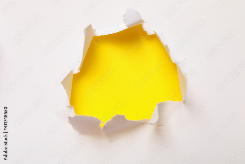 Hole in paper on yellow background, space for text Hole in paper on yellow background, space for text