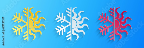 Paper cut Hot and cold symbol. Sun and snowflake icon isolated on blue background. Winter and summer symbol. Paper art style. Vector.