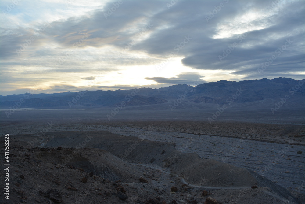 evening sky with the sun breaking through clouds with a view to the panamint range and the Death Valley Wash in the National Park evening sky with the sun breaking through clouds with a view to the panamint range and the Death Valley Wash in the National Park