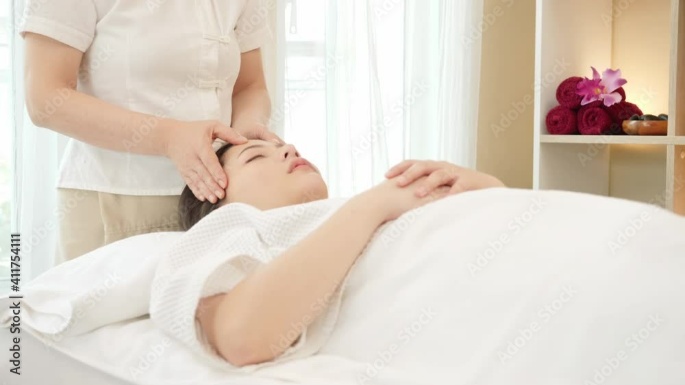 Young Asian woman getting spa massage treatment at beauty spa salon. Face massage, Relaxing massage, Spa skin and body care. slider shot slow Motion Young Asian woman getting spa massage treatment at beauty spa salon. Face massage, Relaxing massage, Spa skin and body care. slider shot slow Motion