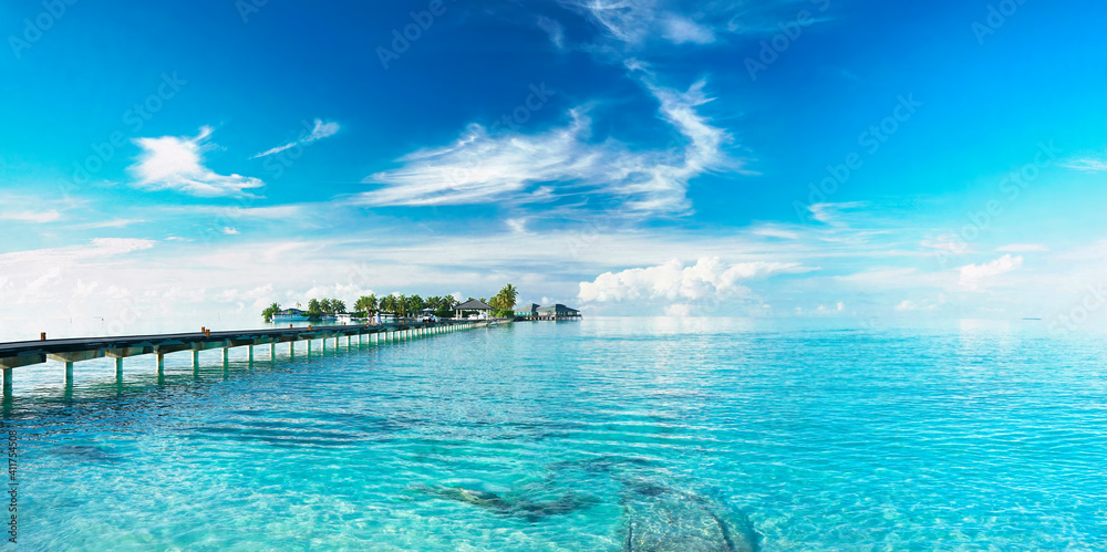 Beautiful landscape with bridge to pier. Color fusion of ocean and sky. Light ripples on amazingly clear water. Perspective receding into distance. Image fine vacation on summer. Relax and rest.