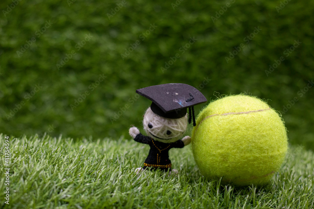 Naklejka premium Tennis player Graduate with green grass background