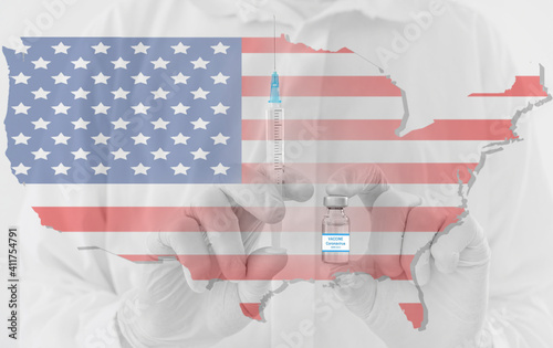 Doctor hands holding a vaccine bottle and syringe, with map of United States of America. Beginning of mass vaccination in USA for coronavirus COVID-19 conceptual photo.