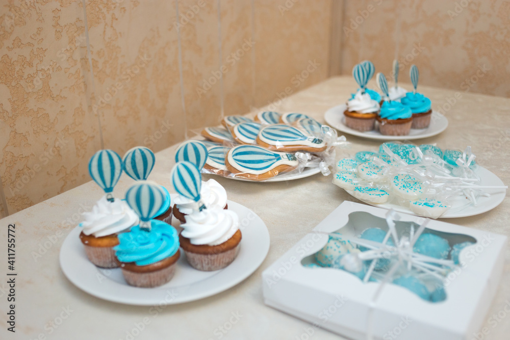 The big cake is decorated with a figurine of a lion cub in a balloon. Candy bar in blue and white for the boy's birthday. The big cake is decorated with a figurine of a lion cub in a balloon. Candy bar in blue and white for the boy's birthday.