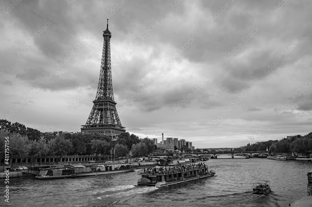 Obraz premium Paris, France - July 18, 2019: Black and white photograph of tourist boats navigating the River Seine and Eiffel Tower in Paris, France