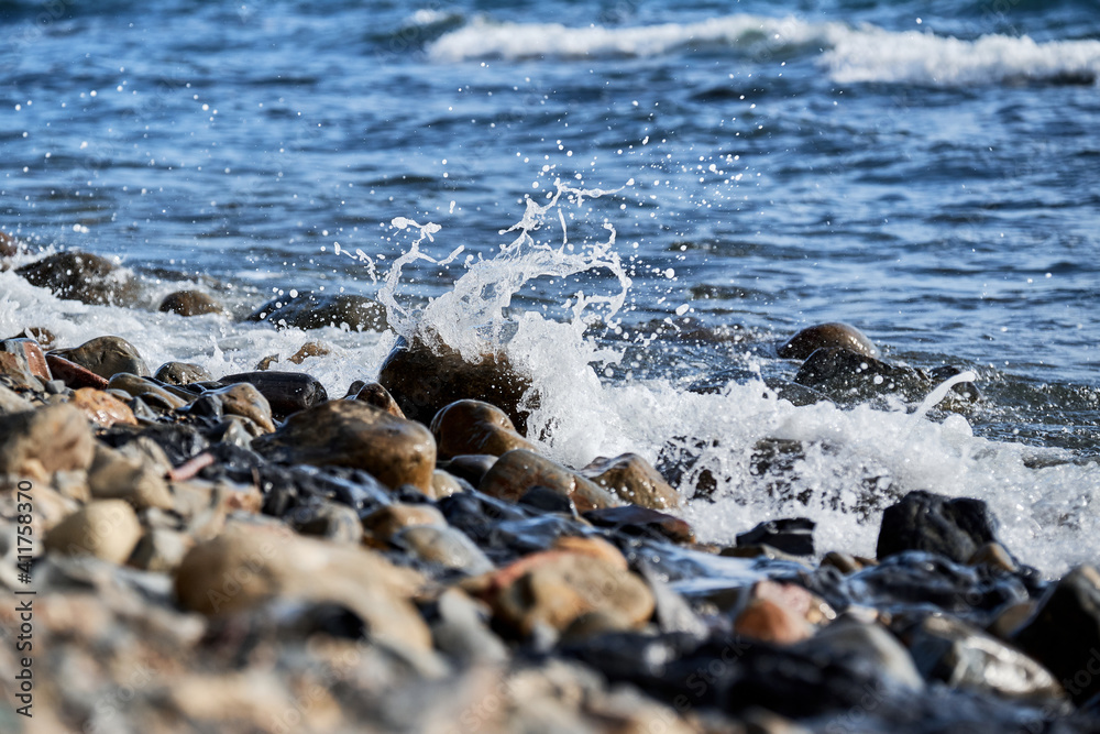Sea waves break on shingle beach. Small wave rolls onto shore and splash of foam flies in different directions. Beautiful marine minimalist screensaver. Sea waves break on shingle beach. Small wave rolls onto shore and splash of foam flies in different directions. Beautiful marine minimalist screensaver.