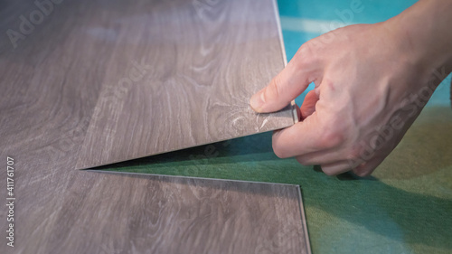 master is laying a new floor, close up
