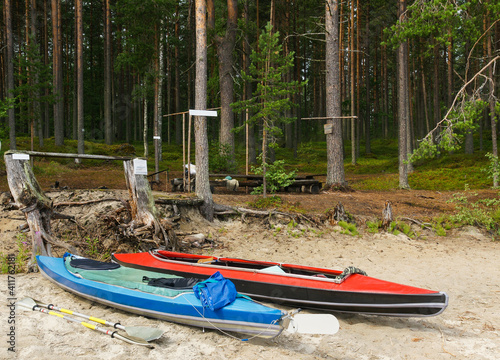 Kayaks on thsandy shore near bench in pine forest, Republic of Karelia, Russia © Alexey Antipov