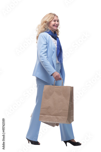 side view. happy woman with shopping bags walking home. © ASDF