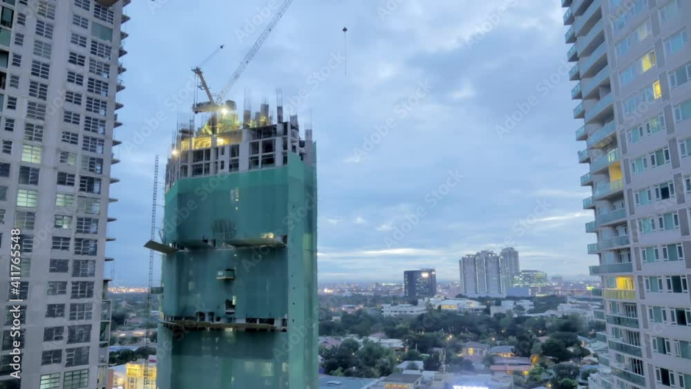 Sunset time-lapse of a building being constructed in Manila. Constructions projects management during pandemic concept. Sunset time-lapse of a building being constructed in Manila. Constructions projects management during pandemic concept.