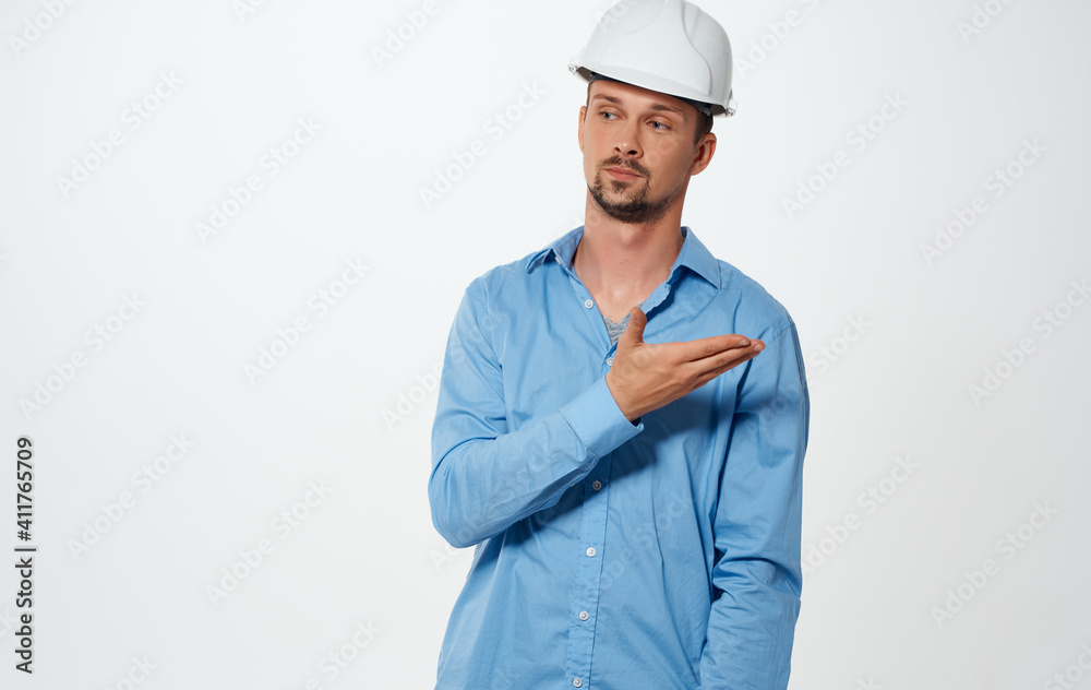 Emotional architect builder in a white helmet and in a blue shirt on an isolated background Emotional architect builder in a white helmet and in a blue shirt on an isolated background