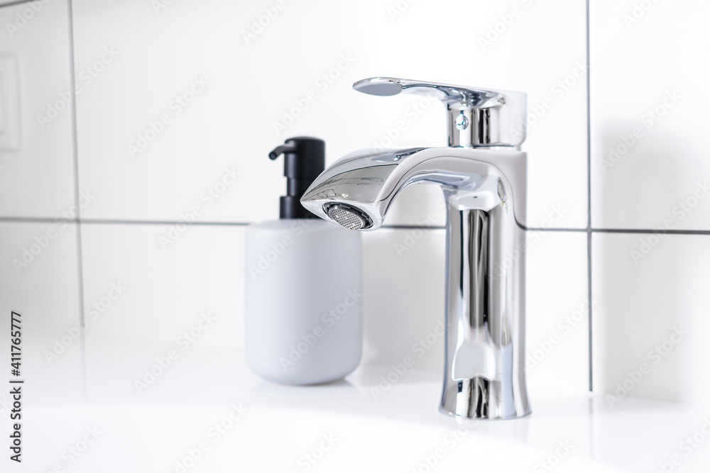 Modern bathroom detail in a luxury home, white sink and chrome tap Modern bathroom detail in a luxury home, white sink and chrome tap