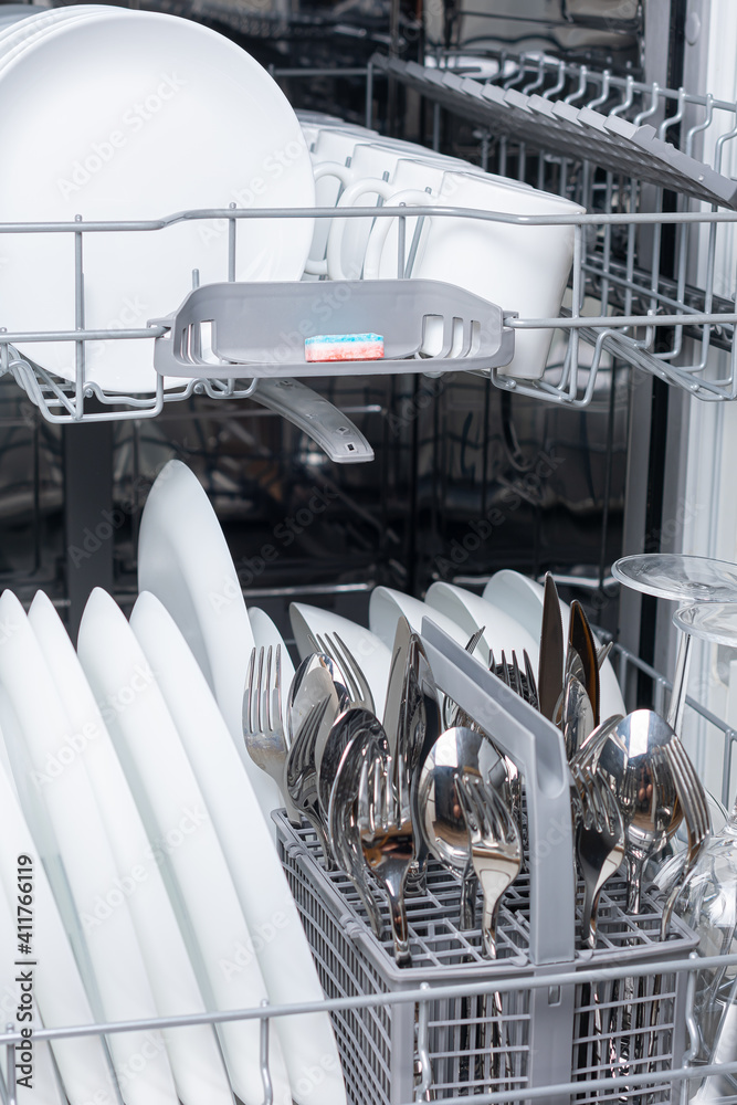Fototapeta premium Open dishwasher with dishes inside