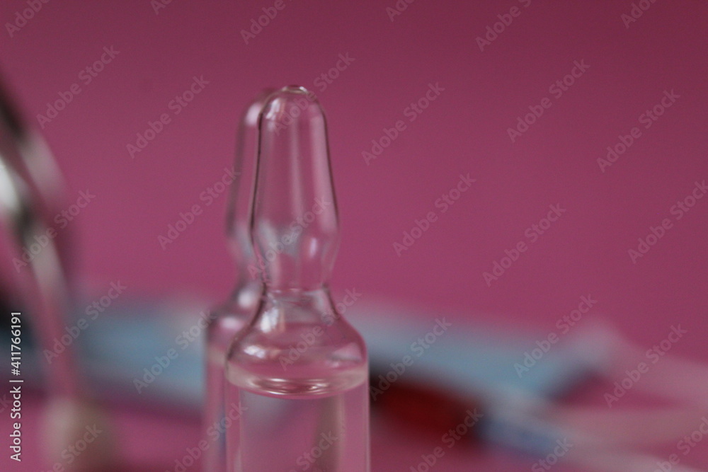 Glass flask close-up on rose-background medicine vaccination Glass flask close-up on rose-background medicine vaccination