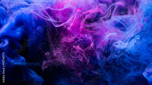 Color explosion. Fluorescent background. Paint in water. Vibrant smoke cloud texture. Glowing neon blue magenta pink steam splash on dark.