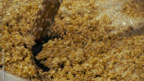 Stir barley to create beer wort at the kitchen close-up