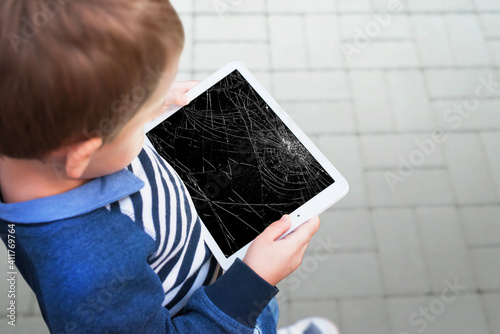 Obraz na płótnie Broken tablet in boy hands concept. Smashed screen after drop
