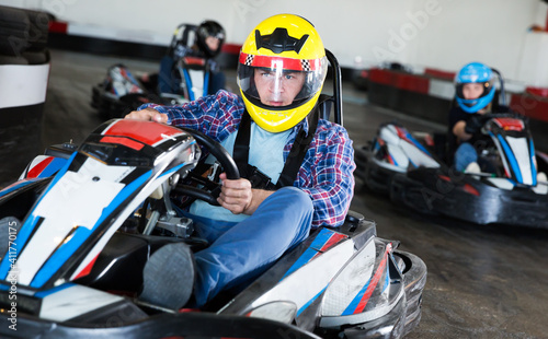 Man driving sport car for karting in a circuit lap in sport club, people on background © JackF