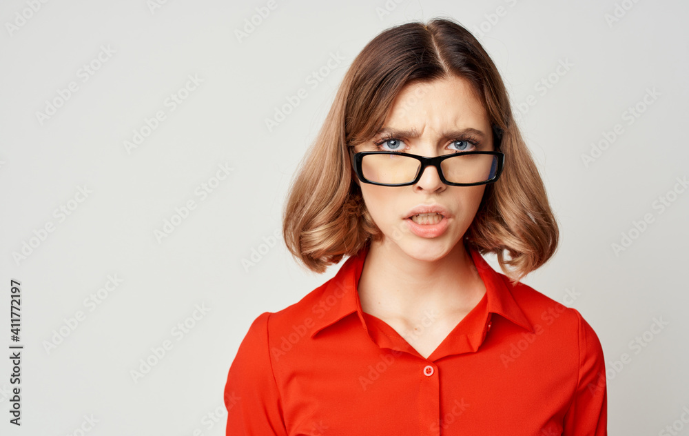 Confident business woman in a red shirt and glasses emotions beige background Confident business woman in a red shirt and glasses emotions beige background