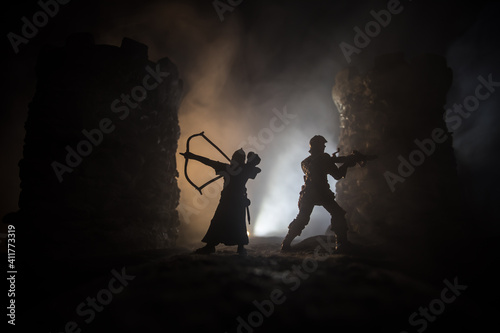 Medieval battle scene. Silhouettes of figures as separate objects, fight between warriors at night. Creative artwork decoration. Foggy background.