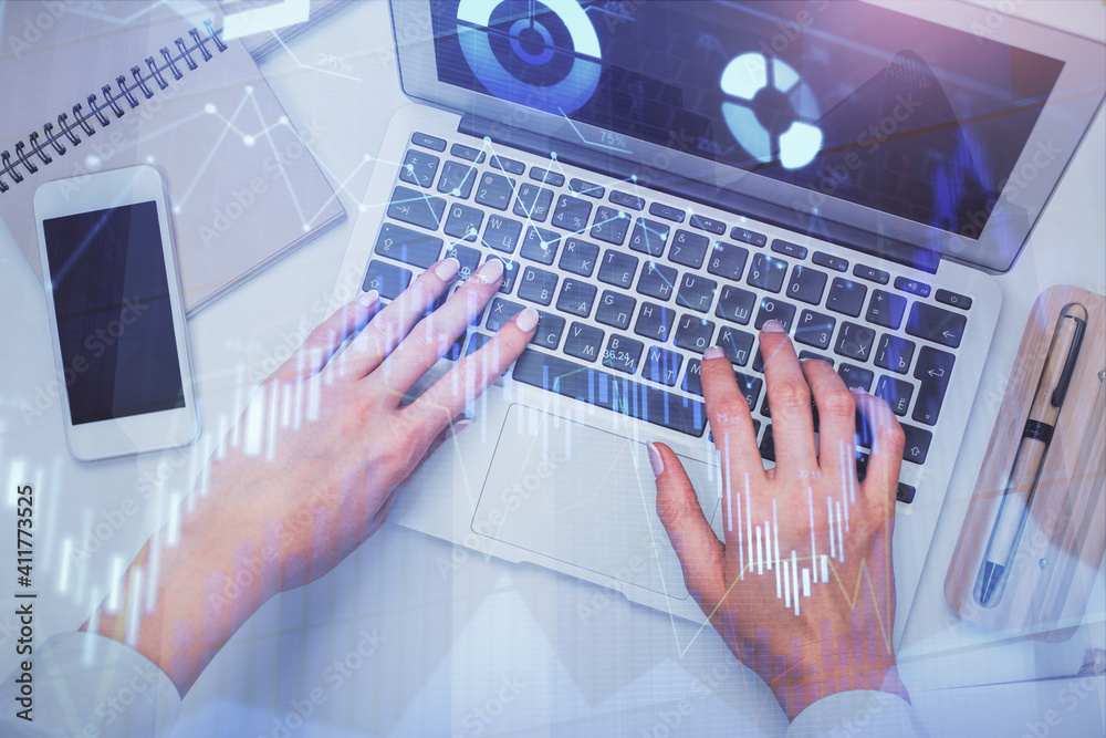 Double exposure of woman hands working on computer and forex graph hologram drawing. Top View. Financial analysis concept. Double exposure of woman hands working on computer and forex graph hologram drawing. Top View. Financial analysis concept.