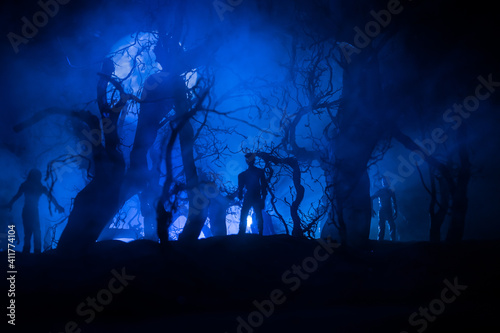 bloodthirsty zombies attacking. hungry zombies in the woods. Silhouettes of scary zombies walking in the forest at night