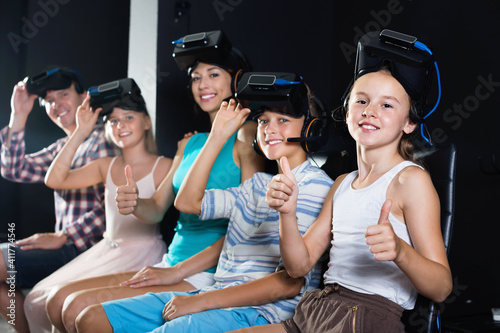 Happy positive family of five is satisfied of VR together in the room.