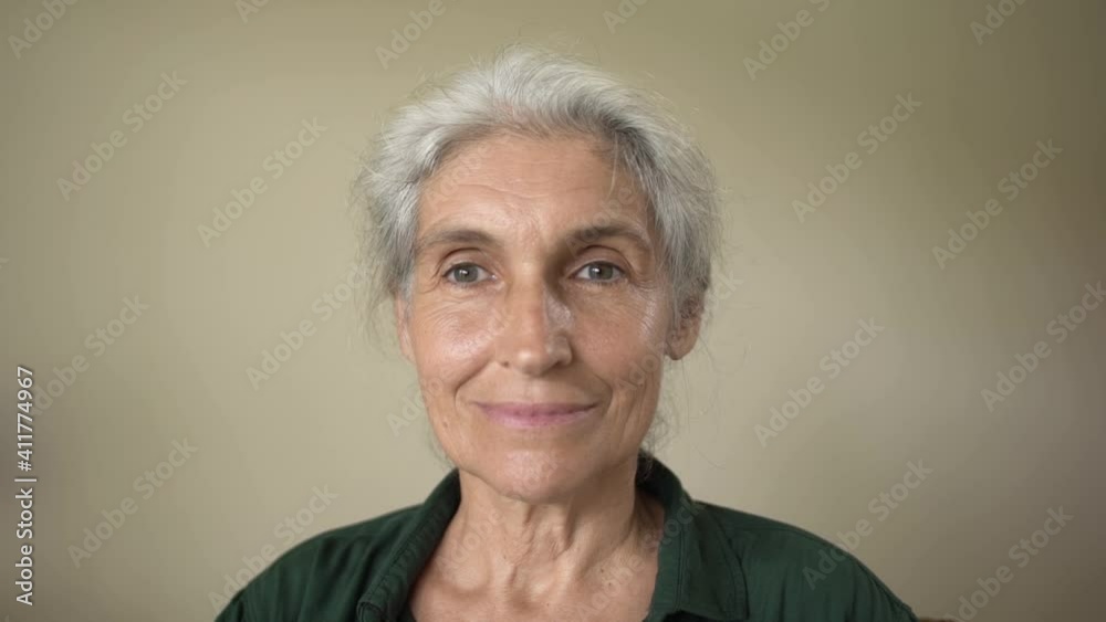 Close-up beautiful happy senior grey-haired woman sitting indoors Close-up beautiful happy senior grey-haired woman sitting indoors