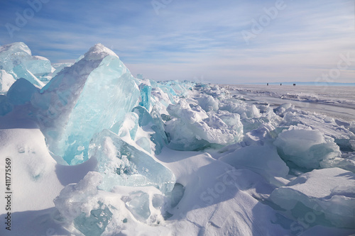 Piles of blue ice fragments covered in snow. Frozen Lake Baikal on a sunny winter day.