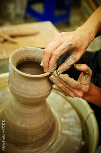 working with clay on potter's wheel