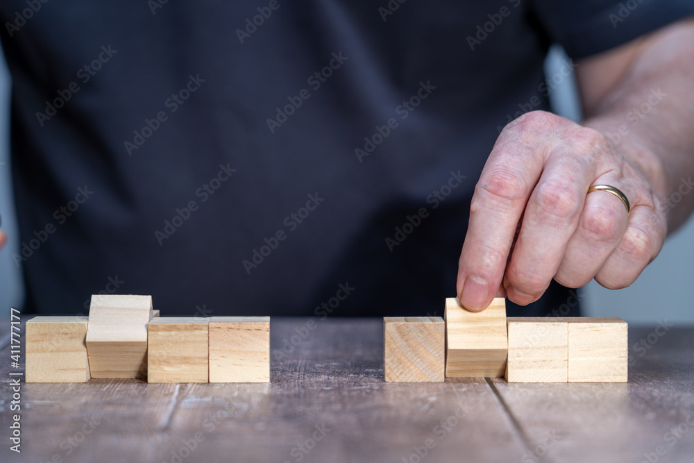blank template mock up of two sets of four timber block cubes , centre ones pivoted with a man in the background holding the centre block blank template mock up of two sets of four timber block cubes , centre ones pivoted with a man in the background holding the centre block