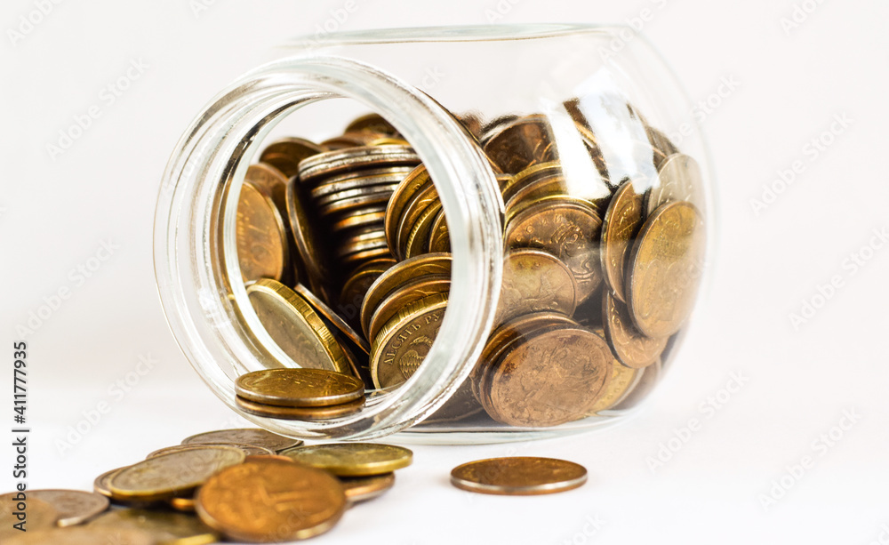 Metal Russian coins lie in a glass jar isolated on a light background. Store and protect savings. Low salary. Financial crisis, currency devaluation concept. Copy space. Selective focus. Metal Russian coins lie in a glass jar isolated on a light background. Store and protect savings. Low salary. Financial crisis, currency devaluation concept. Copy space. Selective focus.