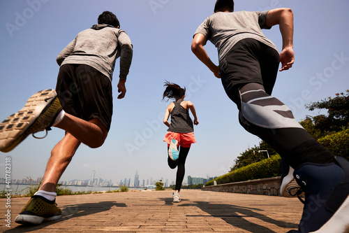 young asian adults running outdoors 