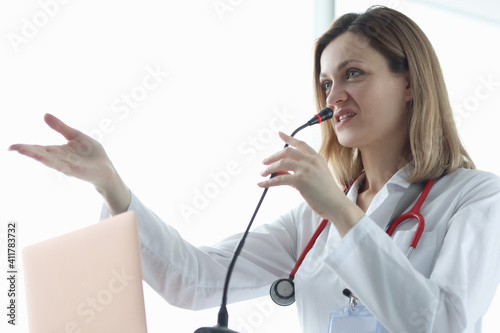 Woman doctor speaking into microphone at presentation