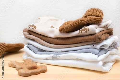 clothes and toys for a newborn on a wooden chest of drawers