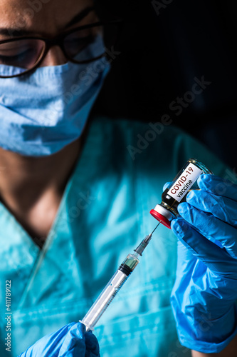 Female doctor holding a COVID-19 vaccine