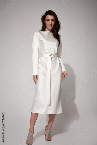 Sexy brunette woman luxury lifestyle bright makeup wear natural organic white silk midi dress wedding bride high heels perfect body shape fashion model style for meeting party romantic date studio.