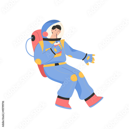 Male astronaut drinking soda and flying in zero gravity