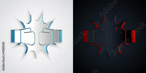 Paper cut Punch in boxing gloves icon isolated on grey and black background. Boxing gloves hitting together with explosive. Paper art style. Vector.