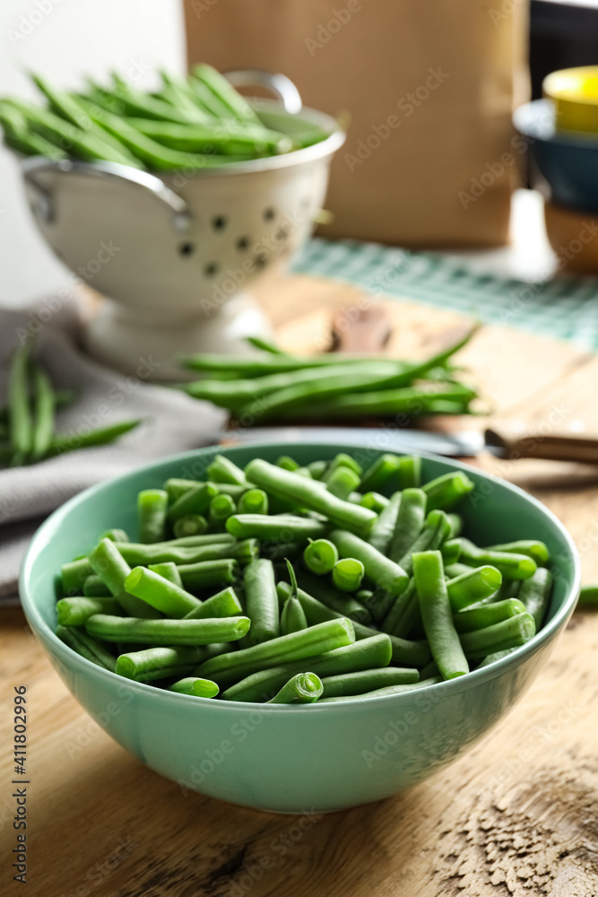 Fresh green beans in bowl on wooden table, closeup. Space for text Fresh green beans in bowl on wooden table, closeup. Space for text
