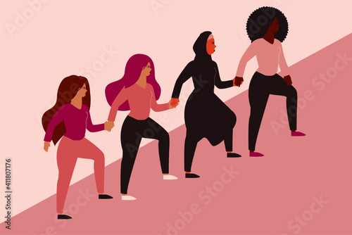 Group of women climbing highly and hold hands. Four different nationalities represent friendship and sisterhood symbol. Females support each others and hold hands. Women empowerment movement concept.