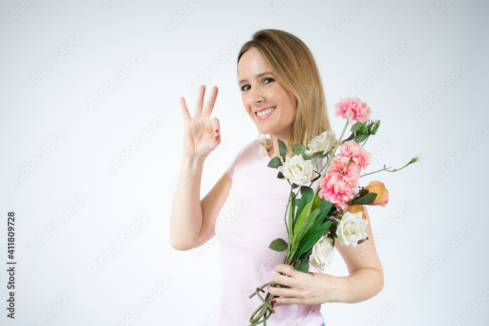 Portrait of a beautiful young woman in casual t-shirt holding big bouquet of flowers isolated over white background Portrait of a beautiful young woman in casual t-shirt holding big bouquet of flowers isolated over white background